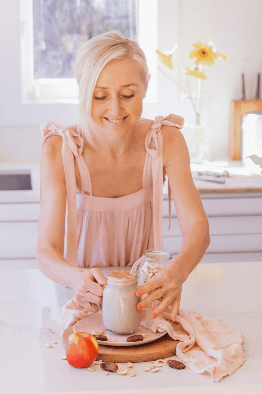 gif of buffy ellen woman holding and drinking apple smoothie in mason jar