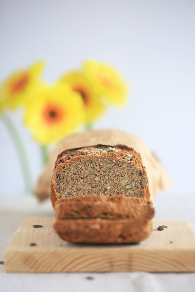 sliced vegan five seed sourdough bread with sunflowers in background