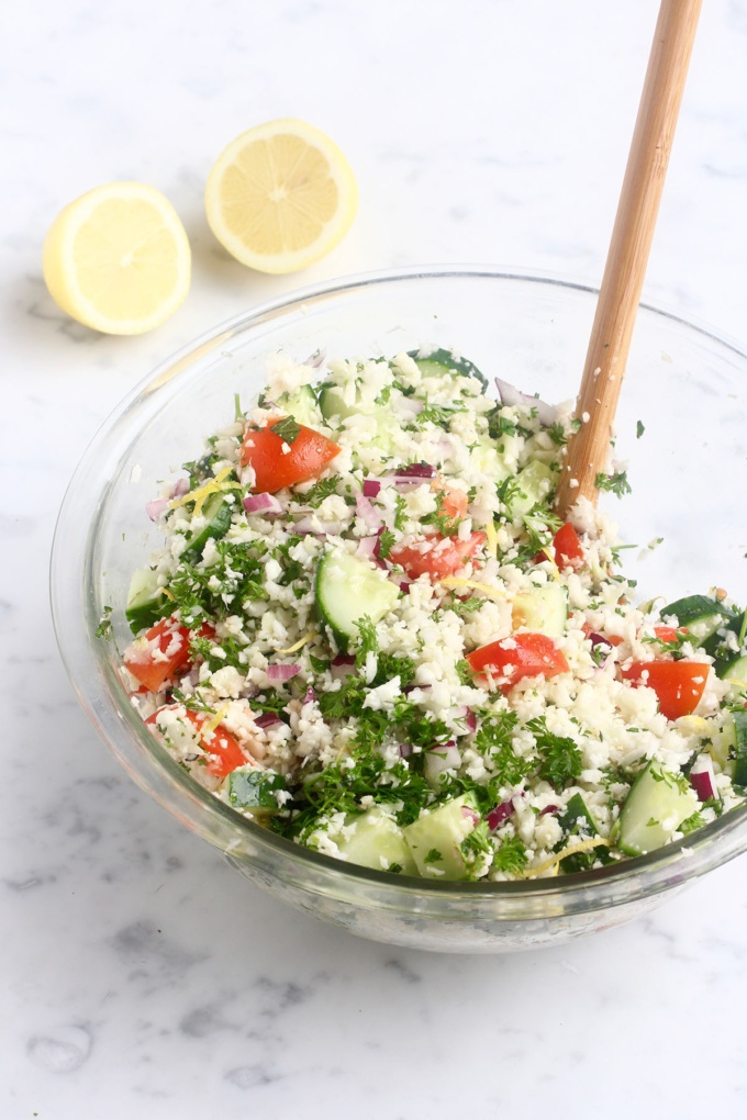 mixing of cauliflower tabouli on white bench with wooden spoon