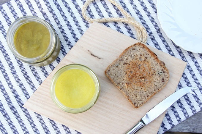 Top down image of Turmeric butter with sourdough toast and metal knife on wooden board 