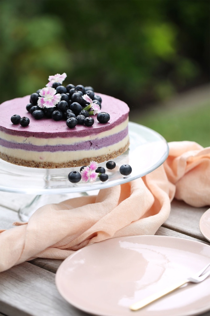 vegan Blueberry and Beetroot cheesecake with pink plates, blueberries and flowers