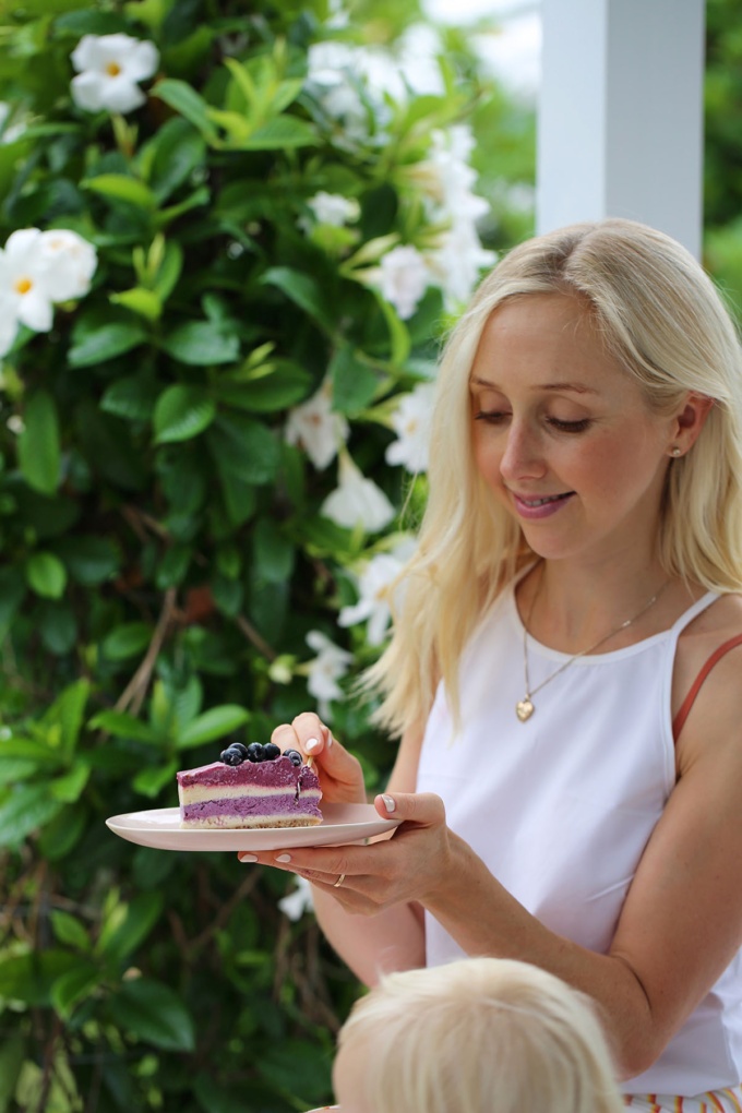 Buffy Ellen taking slice of blueberry and beetroot vegan cheesecake