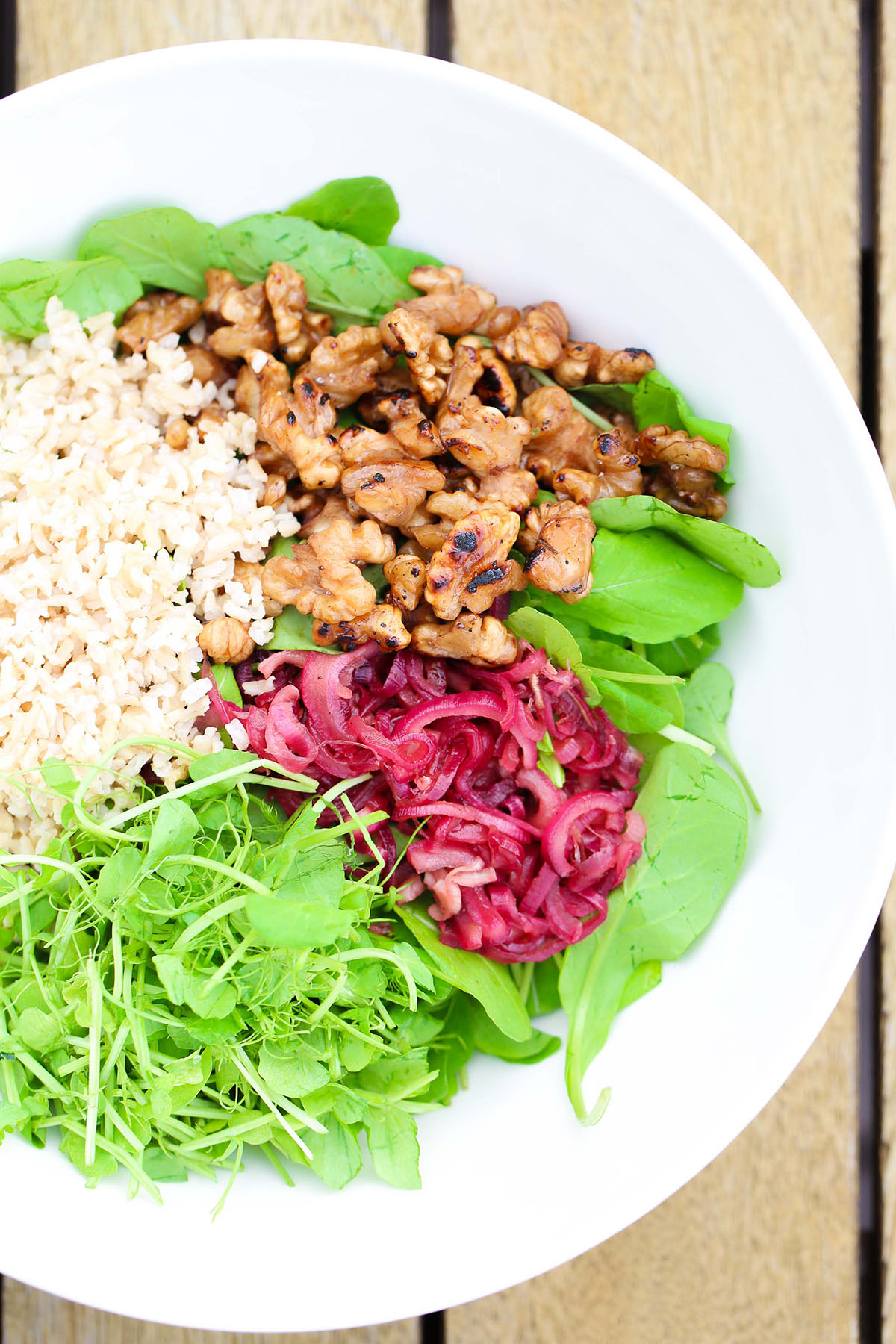 Delicious seasonal feijoa recipe, a savoury way to use feijoas in a salad, with caramelised walnuts, brown rice, caramelised red onions, grounding brown rice, and a sweet balsamic dressing.