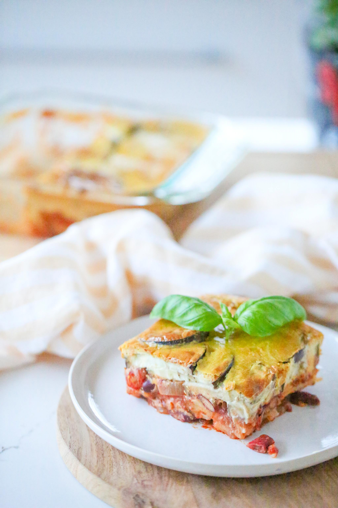 Glorious Greek Moussaka on white plate with basil leaf