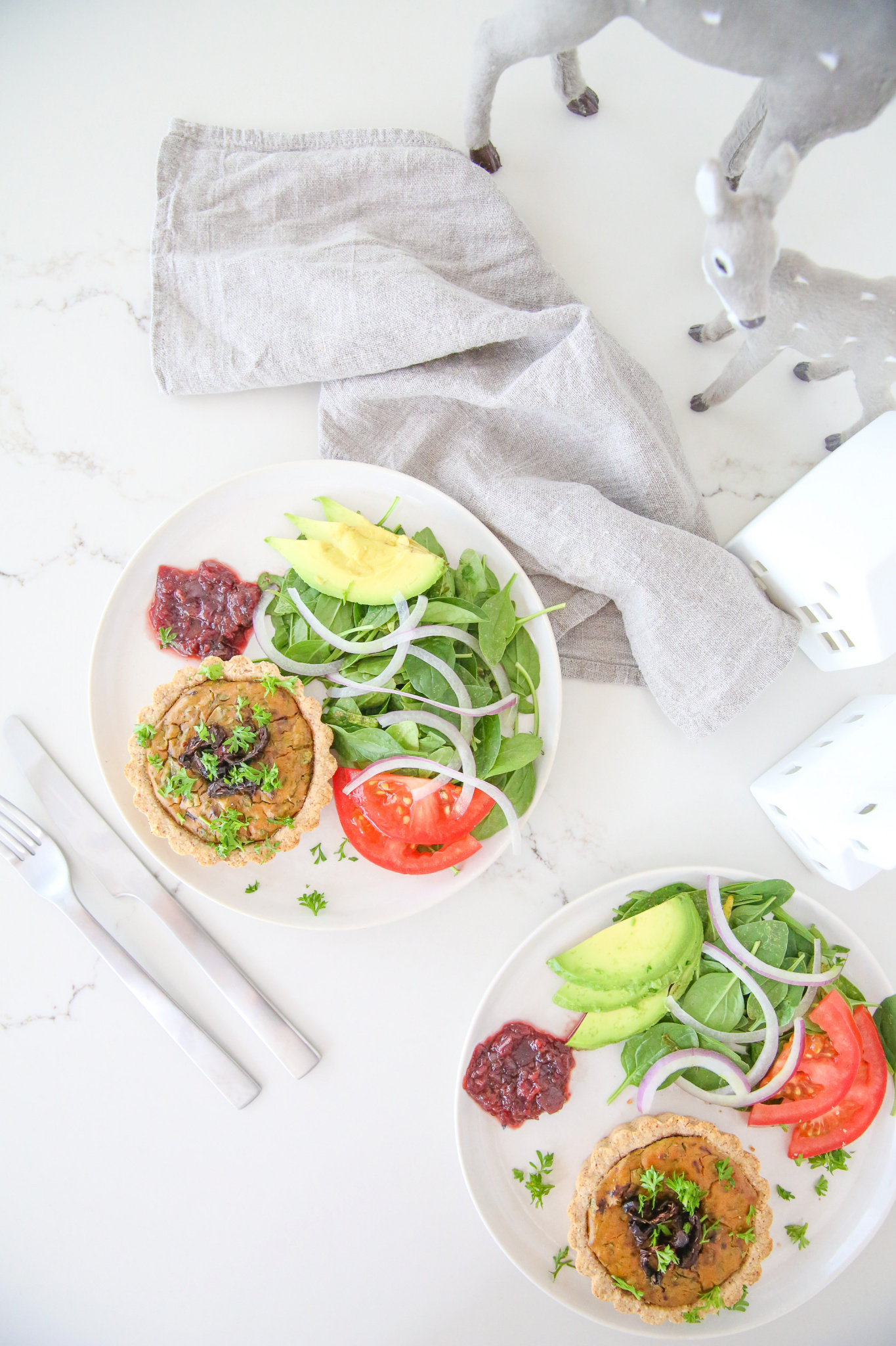 Vegan mini quiches topped with relish, parsley, salad, red onion, tomato, and avocado