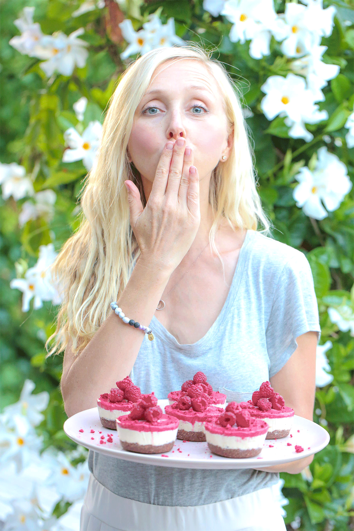 Lady blowing a kiss, holding pretty pink cheesecakes