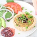 Healthy vegan sundried tomato & spinach quiche with relish, parsley, salad, tomato, avocado, and red onion