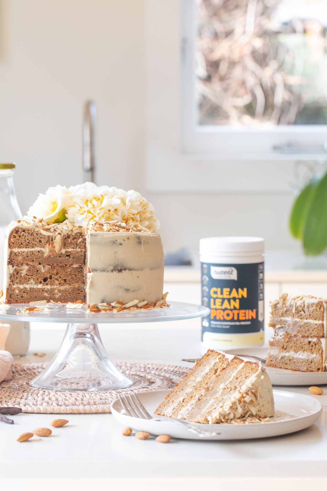 4 layer vanilla cake with white chocolate ganche using flowers and almond with nuzest clean lean protein powder