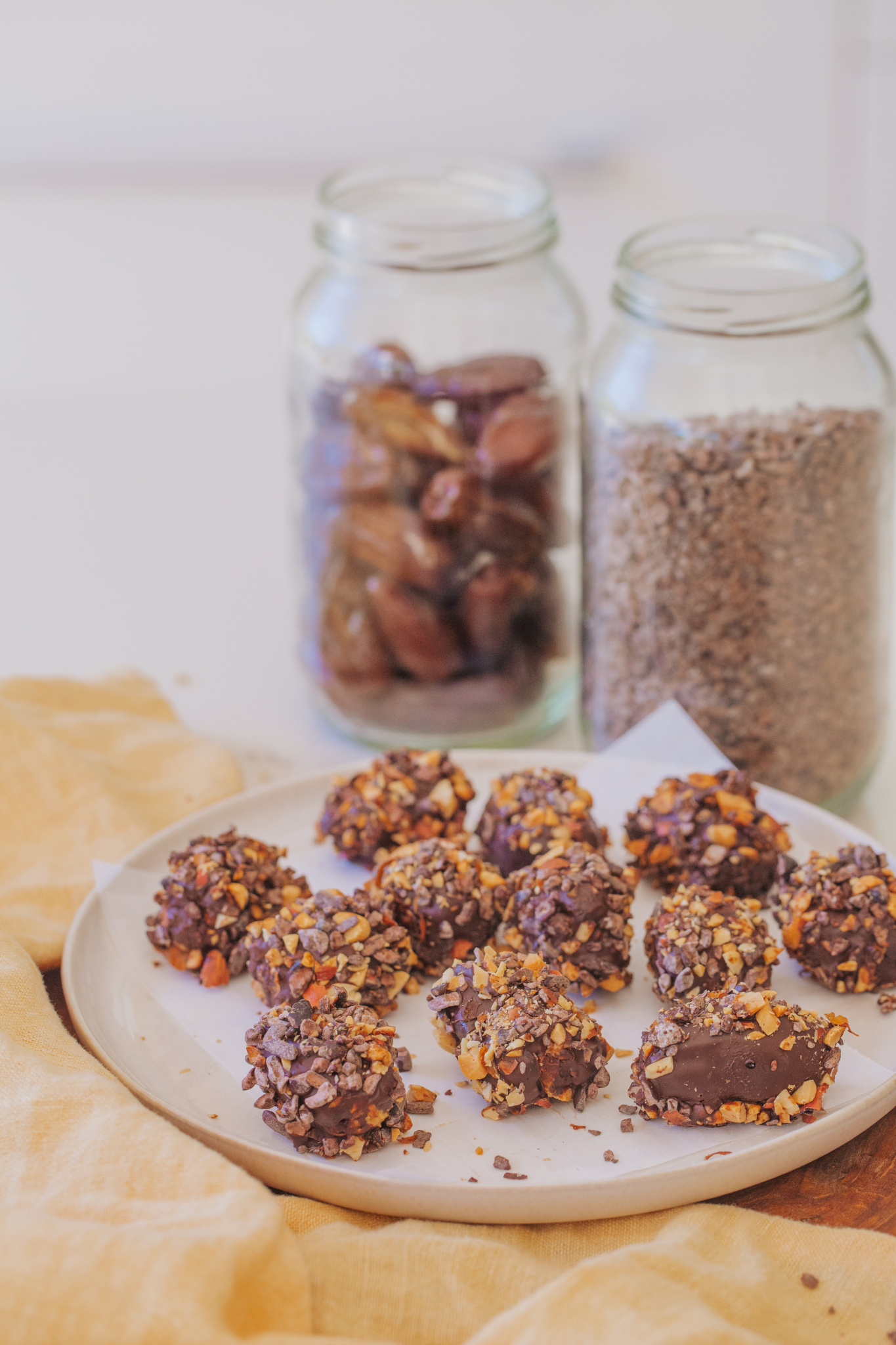 Snickers Bombs with chocolate, dates and cacao nibs over table cloth