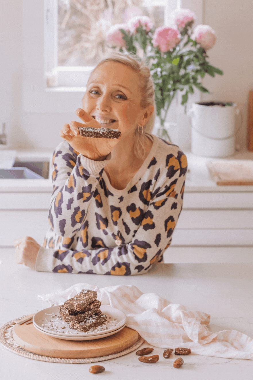 gif of Buffy Ellen holding chocolate lamington bars with pink flowers in background