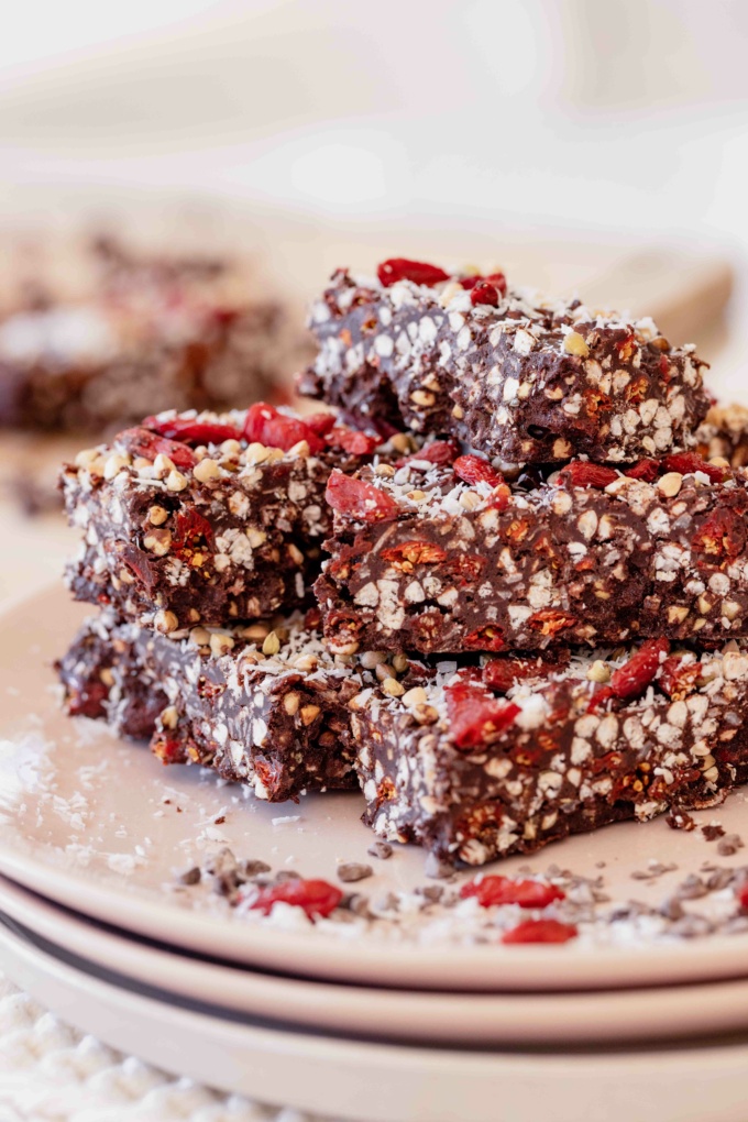 pink plate with stacked chocolate coated goji berries, buckwheat and coconut 