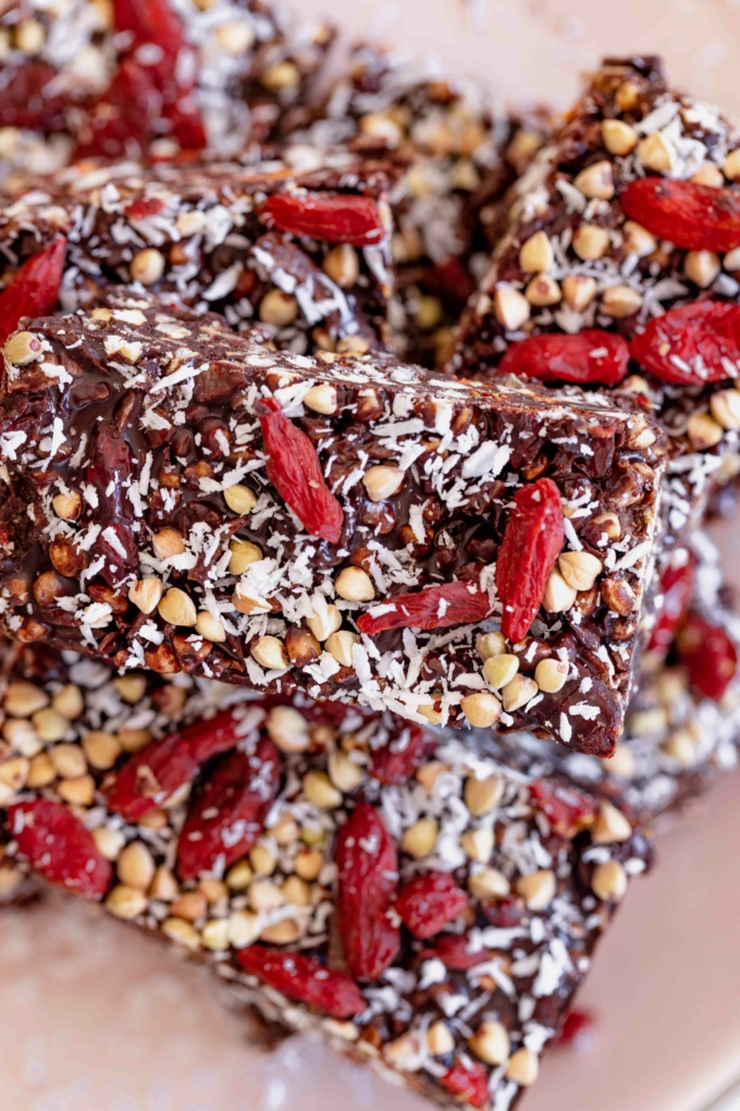 topdown of stacked chocolate coated goji berries, buckwheat and coconut 