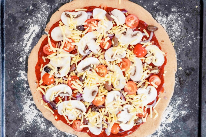 wholemeal dough topped with toppings, tomato sauce, red onion, mushrooms, tomatoes, olives, basil and cheese